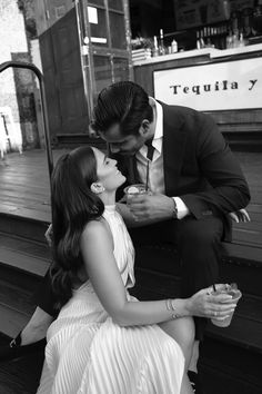 a man in a suit kissing a woman on the cheek while sitting on a bench