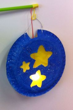 a blue paper plate with yellow stars on it and a green pencil next to it