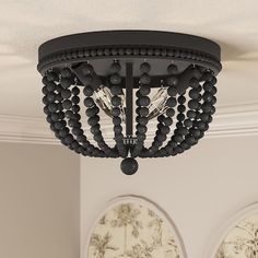 a black chandelier hanging from the ceiling in a room with two pictures on the wall