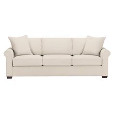 a white couch with two pillows on it's back and one arm facing the camera