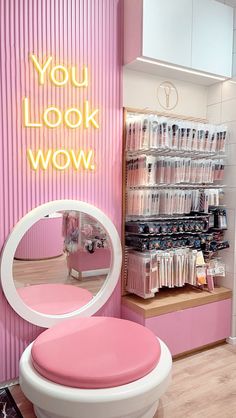 a pink and white chair in front of a mirror with the words you look wow on it