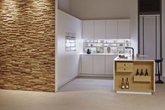 a modern kitchen with white cabinets and wooden wall paneling on the back wall, along with an island countertop