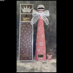 a tall pink vase with a bow on it next to a card and candle holder