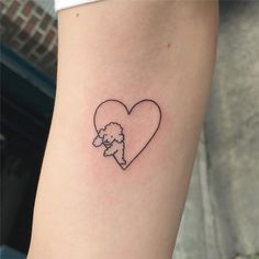 a heart shaped tattoo with a poodle on the inside of it's arm