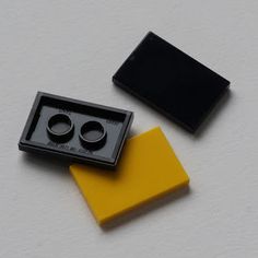 two pieces of black and yellow are sitting next to each other on a white surface