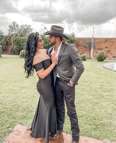 a man and woman standing next to each other in front of a pool wearing cowboy hats