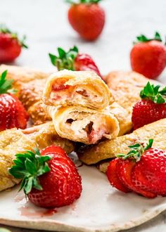 strawberries and pastries are arranged on a plate