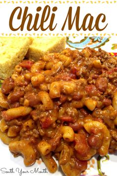 a white plate topped with chili macaroni and cheese next to a piece of bread