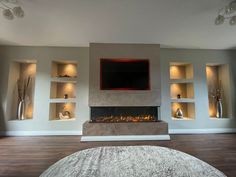 a living room with a large tv mounted on the wall and built - in shelves