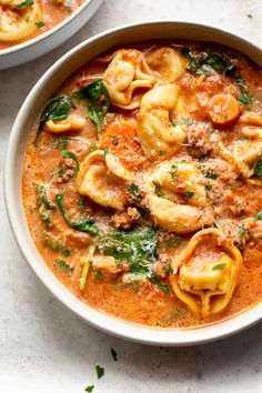 two bowls filled with pasta and meat soup