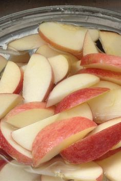 sliced apples are in a glass bowl with water