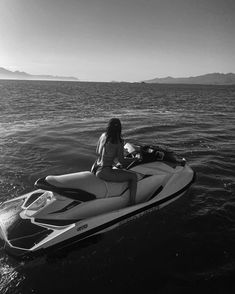 a woman riding on the back of a jet ski