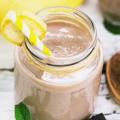 a mason jar filled with smoothie next to a banana and mint