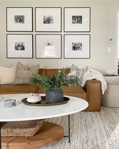 a living room filled with furniture and framed pictures on the wall above a coffee table