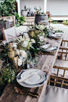 an outdoor table set with plates and place settings