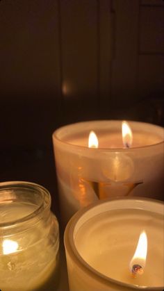 three lit candles sitting next to each other on a table