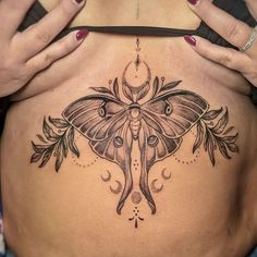 a woman's stomach with a moth tattoo on it