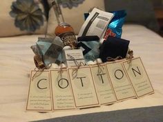 a bed topped with lots of items on top of a white bedspread covered in pillows