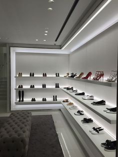 a room filled with lots of shoes and footwear sitting on top of white shelves