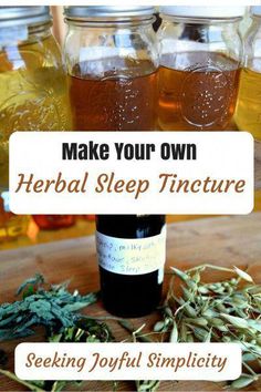 jars filled with liquid and herbs on top of a wooden table