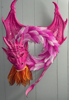 a pink dragon mask hanging on the wall