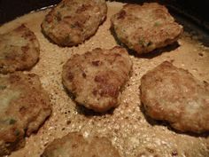 some meat patties are cooking in a pan on the stove top and ready to be cooked