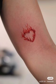 a woman's arm with a red fireball tattoo on it