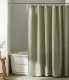 a white bath tub sitting next to a shower curtain