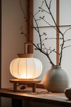 two vases sitting on a table next to a tree with no leaves in it