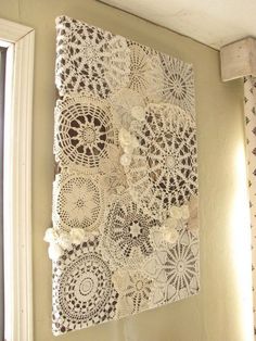 a wall hanging with doily and flowers on it