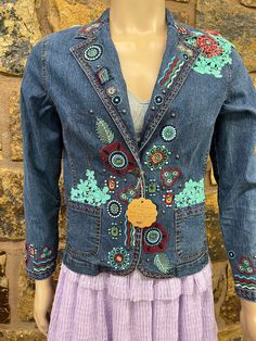 a mannequin wearing a blue jean jacket with colorful flowers on it