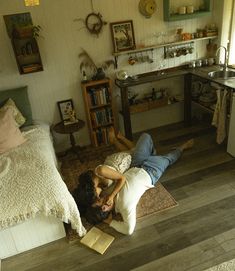 a man and woman laying on the floor in a room with wood floors, bookshelves