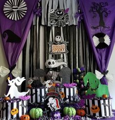 a table topped with lots of halloween decorations and decorating on top of purple curtains