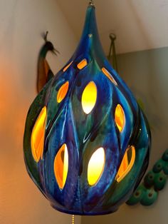 a blue and yellow lamp hanging from a ceiling