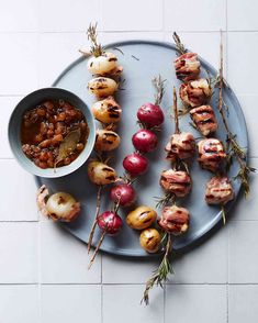 an overhead view of food on a plate, including skewered meats and radishes