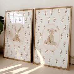 two framed pictures sitting next to each other on top of a floor near a potted plant