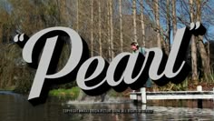 a large sign that says pearl in front of some water and trees with the word pearl on it