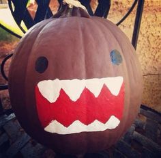 a pumpkin decorated to look like a monster's mouth with sharp teeth on it