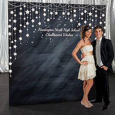 a man and woman standing in front of a backdrop