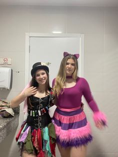 two women dressed up in costumes standing next to each other on a bathroom counter top