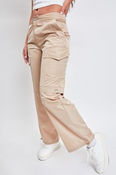 Comfort just got cuter. Meet our Women’s High Rise Nylon Cargo Pants With Bungee Hem - your new closet favorite. This high waisted parachute style pant is constructed with lightweight polyester for a nice airy feel and features decorative grommet detailing to add to the vintage military aesthetic. Fitted with an adjustable bungee tie at the hem so you can alter the look with a straight leg or cinched ankle depending on your mood. Style with a fitted rib tank and boots for an edgy look, or a body Beige Full-length Parachute Pants For Streetwear, High Waist Solid Parachute Pants With Cargo Pockets, High Waist Utility Parachute Pants For Outdoor, High Waist Parachute Pants With Multiple Pockets For Outdoor, Utility High Waist Parachute Pants For Outdoor, High-waist Utility Parachute Pants For Outdoor, High Waist Parachute Pants With Cargo Pockets For Outdoor, Trendy Outdoor Cargo Pants With Elastic Waistband, Khaki High Waist Cargo Parachute Pants