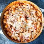 a bowl filled with pasta and sauce on top of a table