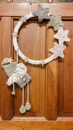 a wooden door with a wreath made out of yarn and stars hanging from the front