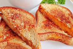 two grilled cheese sandwiches on a white plate next to a cup of coffee and parsley