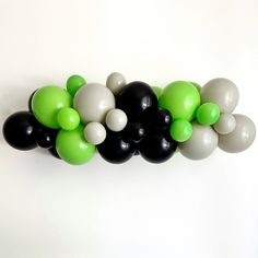 black, white and green balloons are arranged in a row