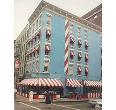 a large blue building with red and white striped awnings on the side of it