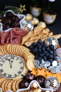 a platter filled with crackers, cheeses, grapes and other food items