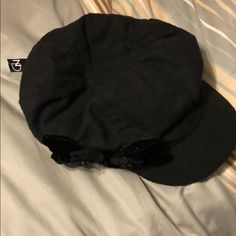 a black hat laying on top of a bed