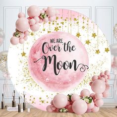 we are over the moon backdrop with balloons and streamers in pink, gold and white