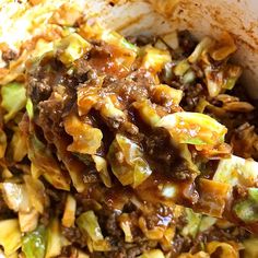 a close up of food in a bowl on a wooden spoon with other foods around it